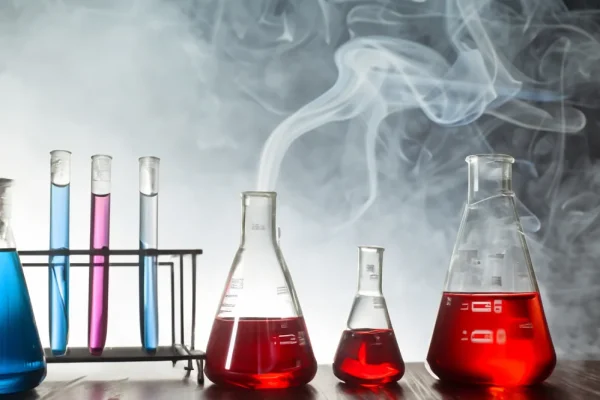 Beakers from a lab with smoke coming from them.