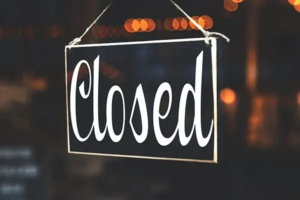 Restaurant closed sign with tables listed for sale.