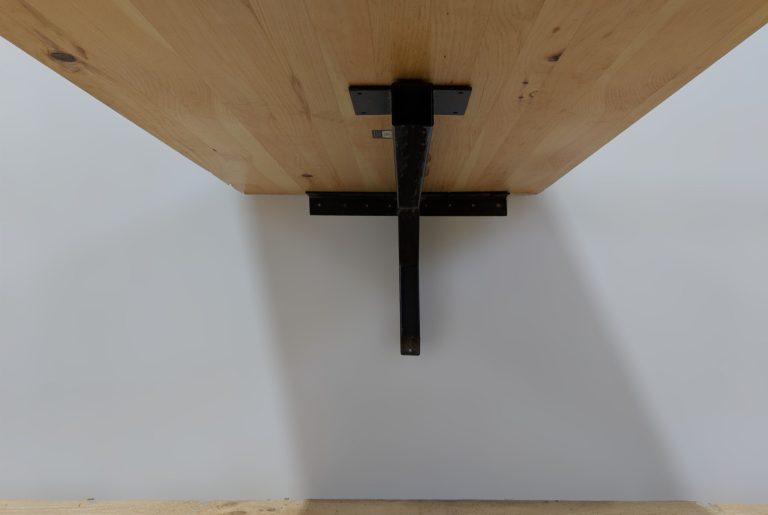 Cantilever base under a restaurant table top that is ADA compliant. Photo is taken from the underside at the end so you can see both the catilever base and the ADA restaurant table top attached.
